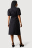 Woman wearing a black dress with puff sleeves on a white background