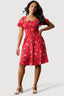 Woman wearing a red floral dress on a white background